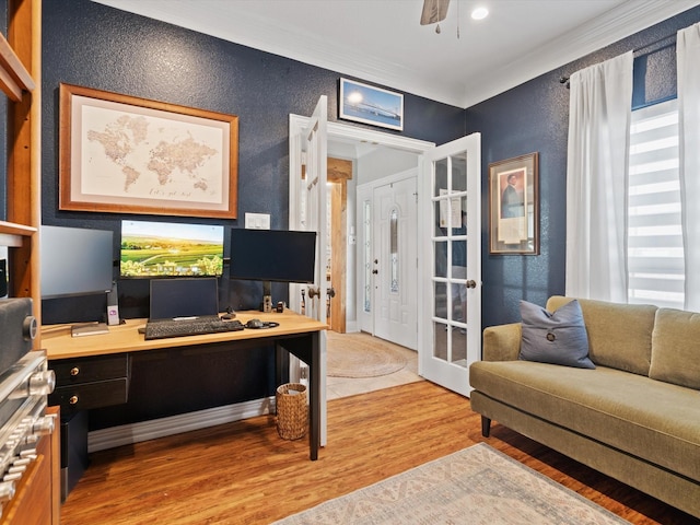 office space with a textured wall, a ceiling fan, ornamental molding, french doors, and light wood finished floors