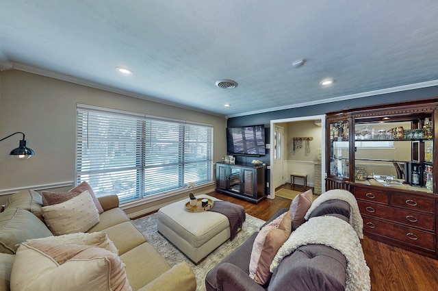 living room featuring crown molding, visible vents, and wood finished floors