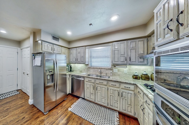 kitchen featuring tasteful backsplash, visible vents, dark wood-style floors, appliances with stainless steel finishes, and a sink