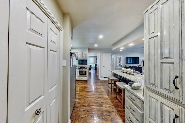 kitchen with open floor plan, appliances with stainless steel finishes, dark wood finished floors, and recessed lighting