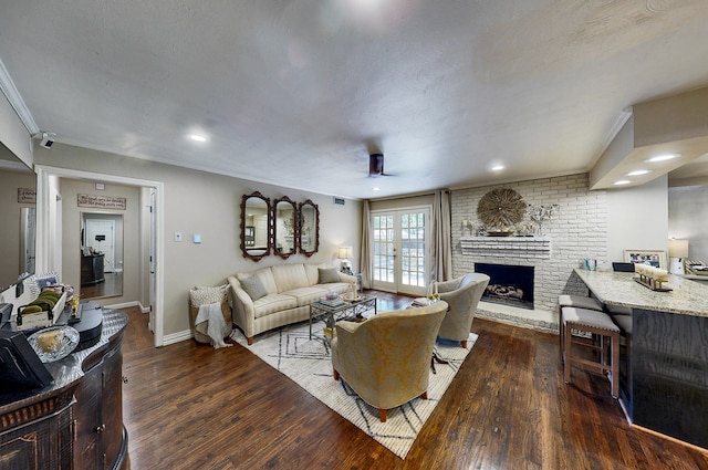 living room with dark wood-style floors, french doors, a brick fireplace, and baseboards