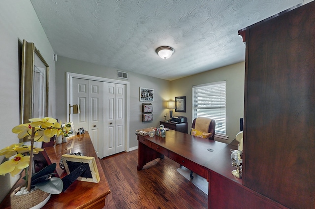 office space featuring visible vents, a textured ceiling, baseboards, and wood finished floors