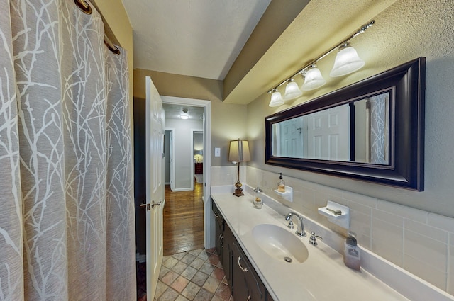 bathroom featuring a wainscoted wall, tile walls, and vanity