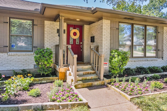 entrance to property featuring brick siding