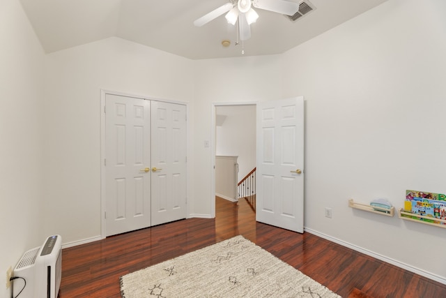 bedroom featuring baseboards, visible vents, wood finished floors, vaulted ceiling, and a closet