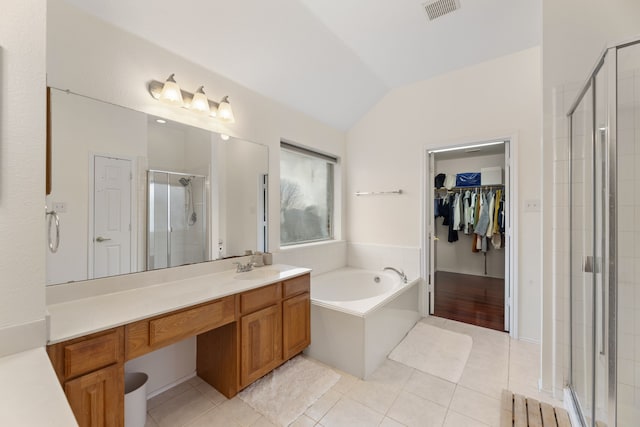 bathroom with visible vents, tile patterned flooring, a walk in closet, vaulted ceiling, and a shower stall