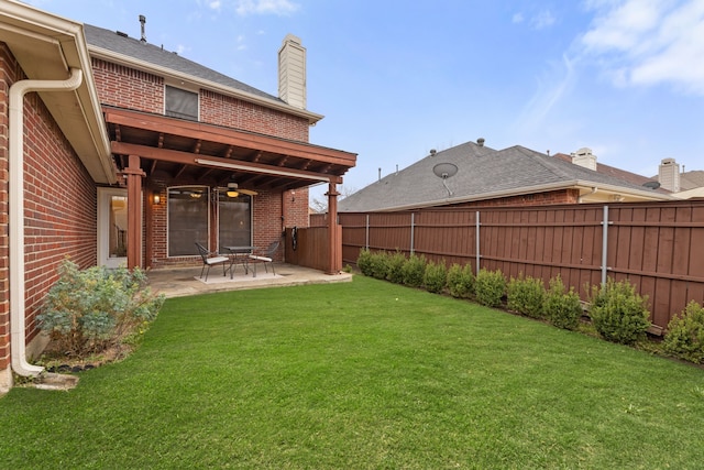 view of yard with ceiling fan, a patio area, and a fenced backyard