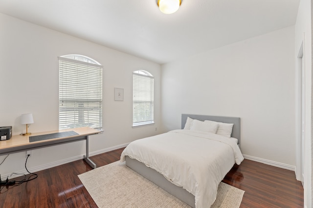 bedroom with dark wood finished floors and baseboards