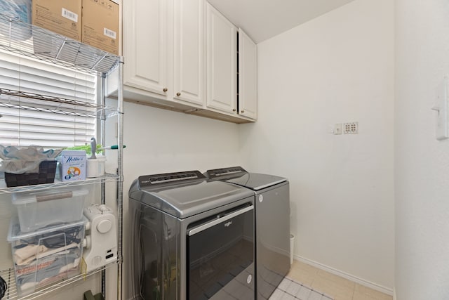 clothes washing area featuring light tile patterned floors, independent washer and dryer, cabinet space, and baseboards