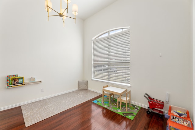 playroom featuring a notable chandelier, wood finished floors, and baseboards