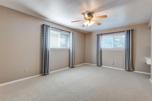 spare room featuring carpet floors, baseboards, and a ceiling fan