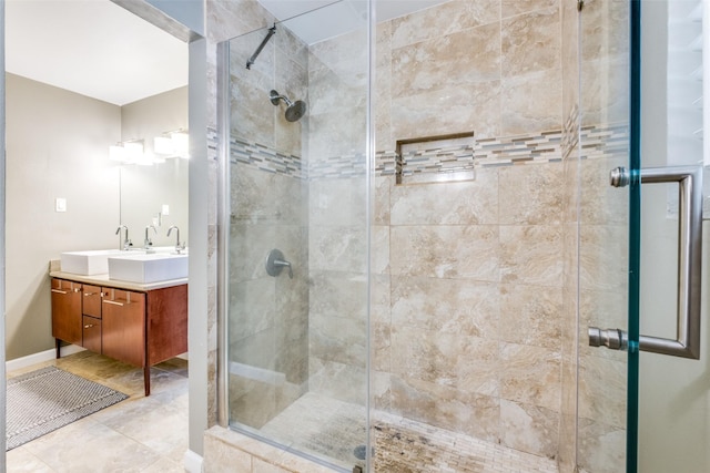 bathroom with a stall shower, tile patterned flooring, baseboards, and vanity