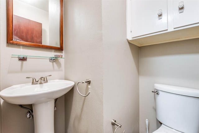 half bathroom featuring a sink and toilet