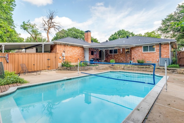 outdoor pool with a gate, a patio area, and fence