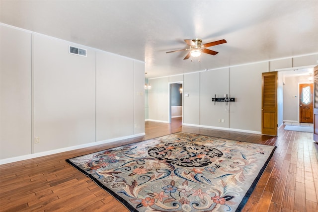 unfurnished room with a ceiling fan, visible vents, and hardwood / wood-style floors