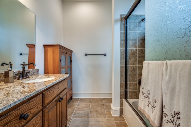 full bath featuring bath / shower combo with glass door, vanity, baseboards, and tile patterned floors