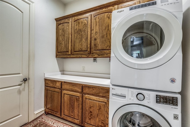 washroom featuring cabinet space and stacked washer and clothes dryer