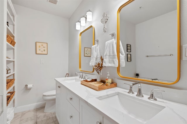 full bathroom with marble finish floor, a sink, toilet, and double vanity