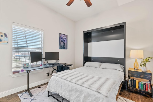 bedroom with wood finished floors, a ceiling fan, and baseboards