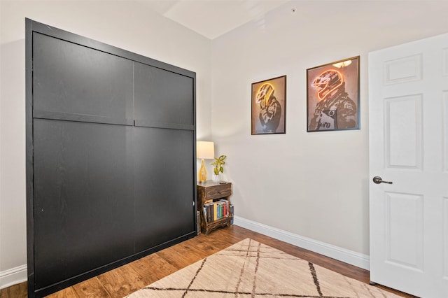 interior space with baseboards and wood finished floors