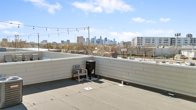 view of patio / terrace featuring a view of city, a balcony, and central AC unit