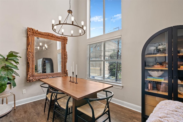 dining room featuring a high ceiling, baseboards, and dark wood-style flooring