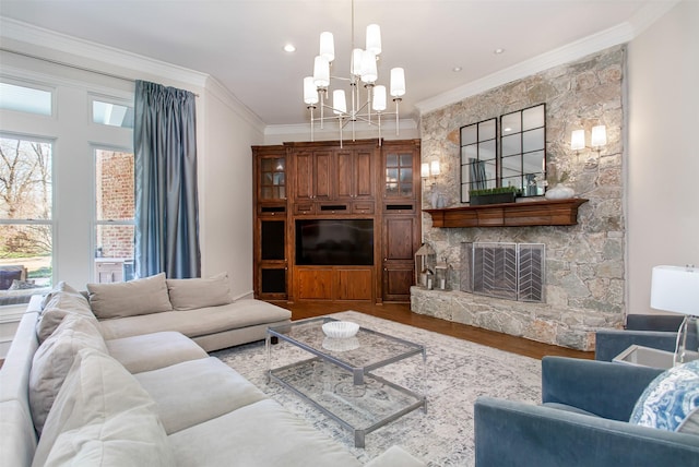 living room featuring a chandelier, wood finished floors, a fireplace, and ornamental molding