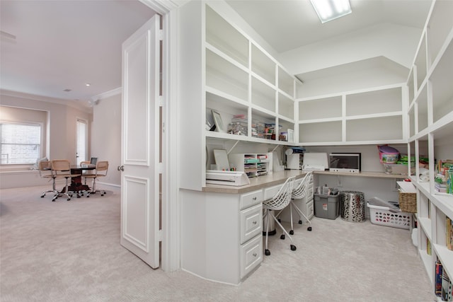 home office with light carpet, ornamental molding, built in study area, and vaulted ceiling