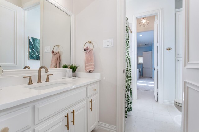 bathroom featuring tile patterned floors, toilet, vanity, and baseboards