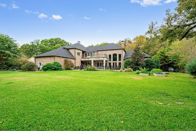 back of house with a yard and a garden