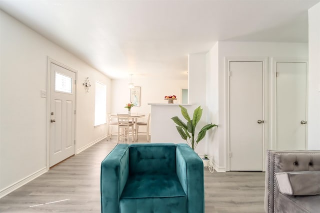 sitting room with baseboards and light wood finished floors