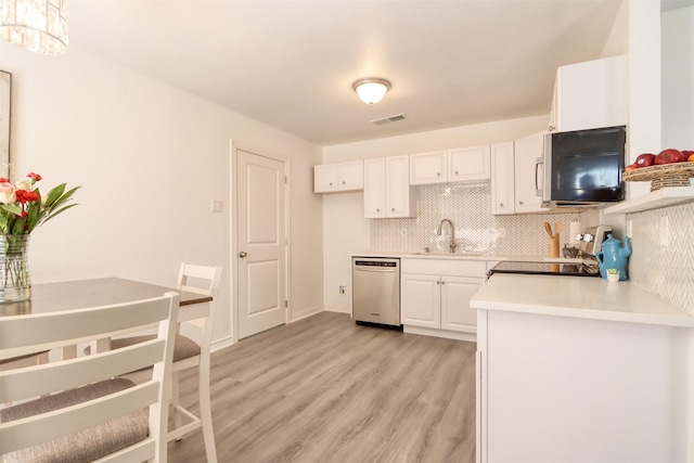 kitchen with visible vents, range, dishwasher, white cabinetry, and a sink