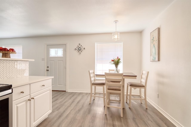 dining room featuring light wood-style floors and baseboards