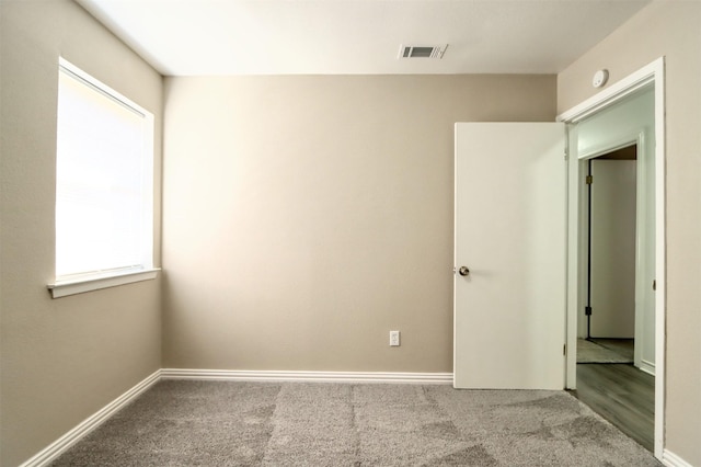 unfurnished bedroom featuring carpet floors, baseboards, and visible vents