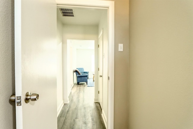 hall featuring visible vents and wood finished floors