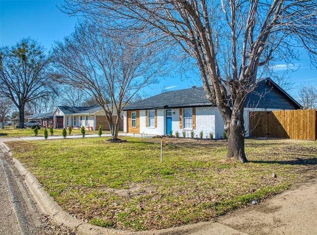 ranch-style house with a front lawn and fence