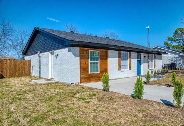 exterior space with a patio area, fence, brick siding, and a lawn