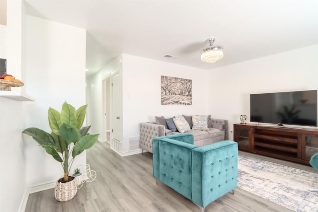 living area with light wood-type flooring, baseboards, and visible vents