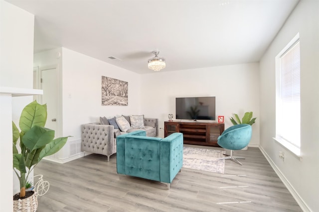 living area featuring light wood-style floors, baseboards, and visible vents