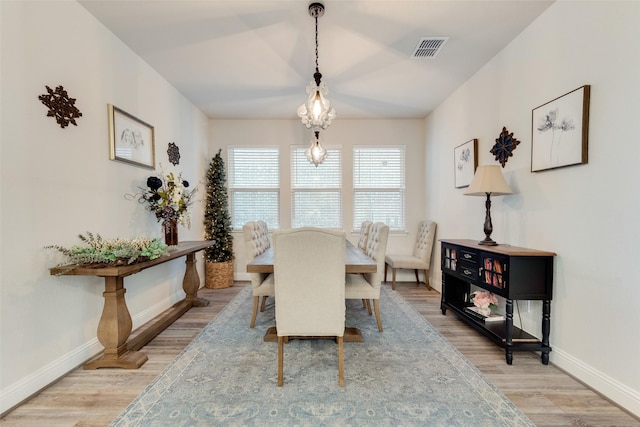 dining area featuring light wood-style flooring, visible vents, and baseboards