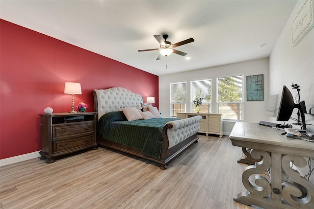 bedroom with light wood-style floors, baseboards, and a ceiling fan