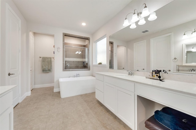 full bathroom featuring a stall shower, baseboards, visible vents, vanity, and a freestanding tub