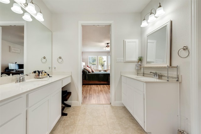 bathroom featuring tile patterned flooring, two vanities, a sink, and ensuite bathroom