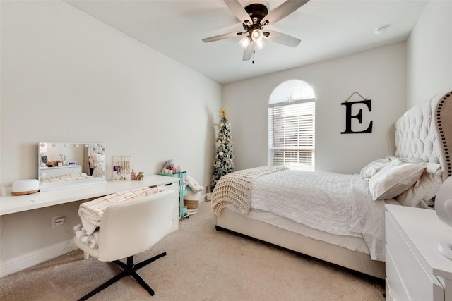 bedroom featuring ceiling fan, baseboards, carpet flooring, and built in study area