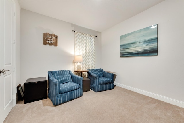 living area featuring carpet and baseboards