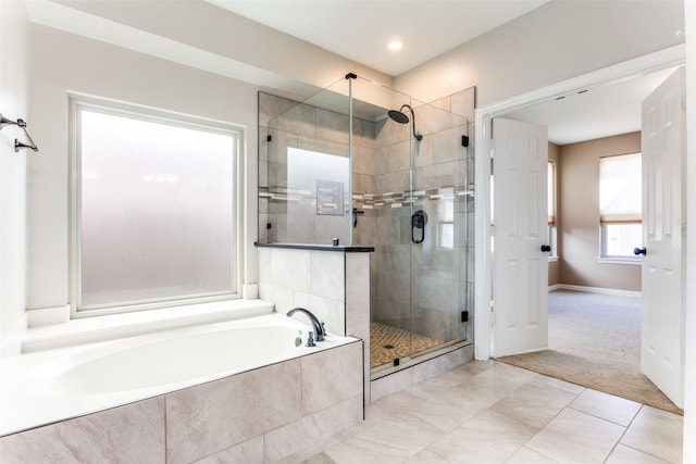 bathroom with a stall shower, baseboards, a garden tub, and tile patterned floors