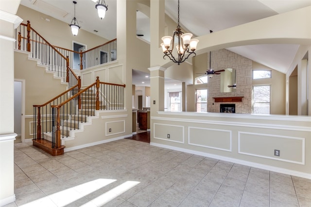 interior space featuring ceiling fan, tile patterned flooring, decorative light fixtures, and a decorative wall