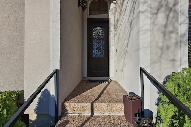 doorway to property featuring stucco siding