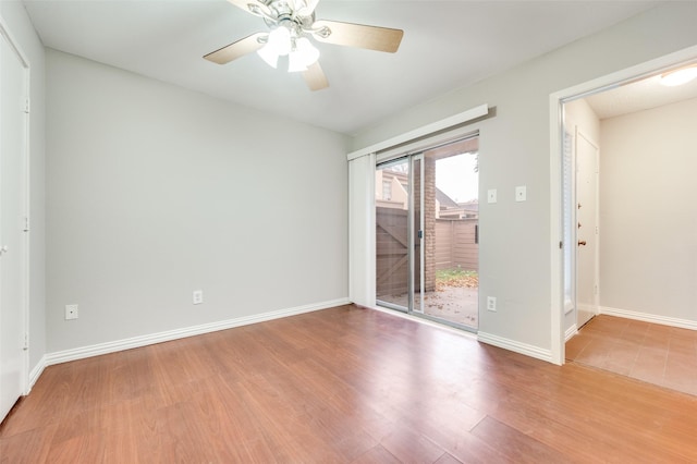 empty room with a ceiling fan, baseboards, and wood finished floors