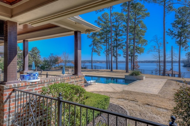 outdoor pool featuring a water view and a patio